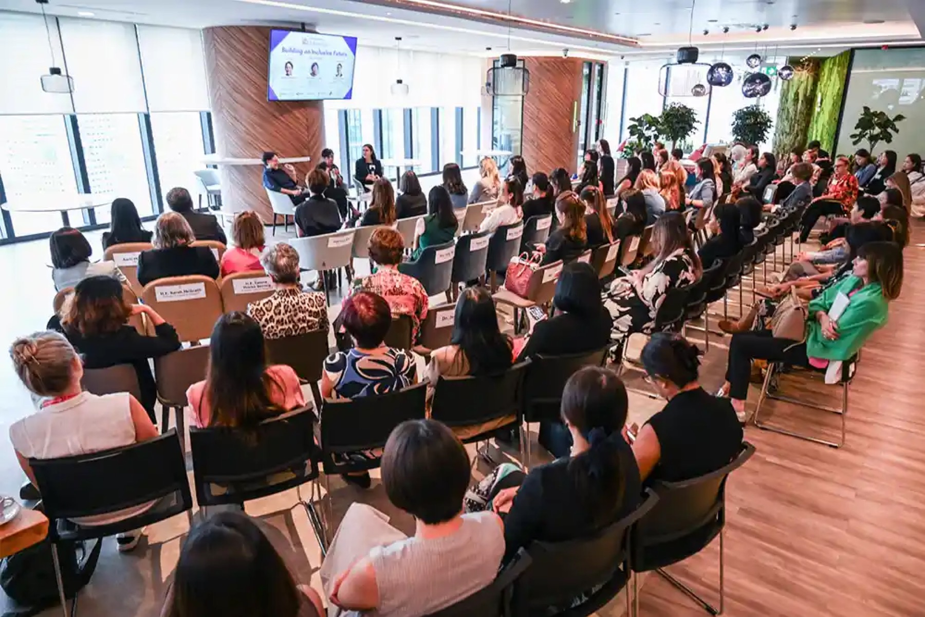 An audience seated in rows facing a three-person panel at an AmCham Singapore session