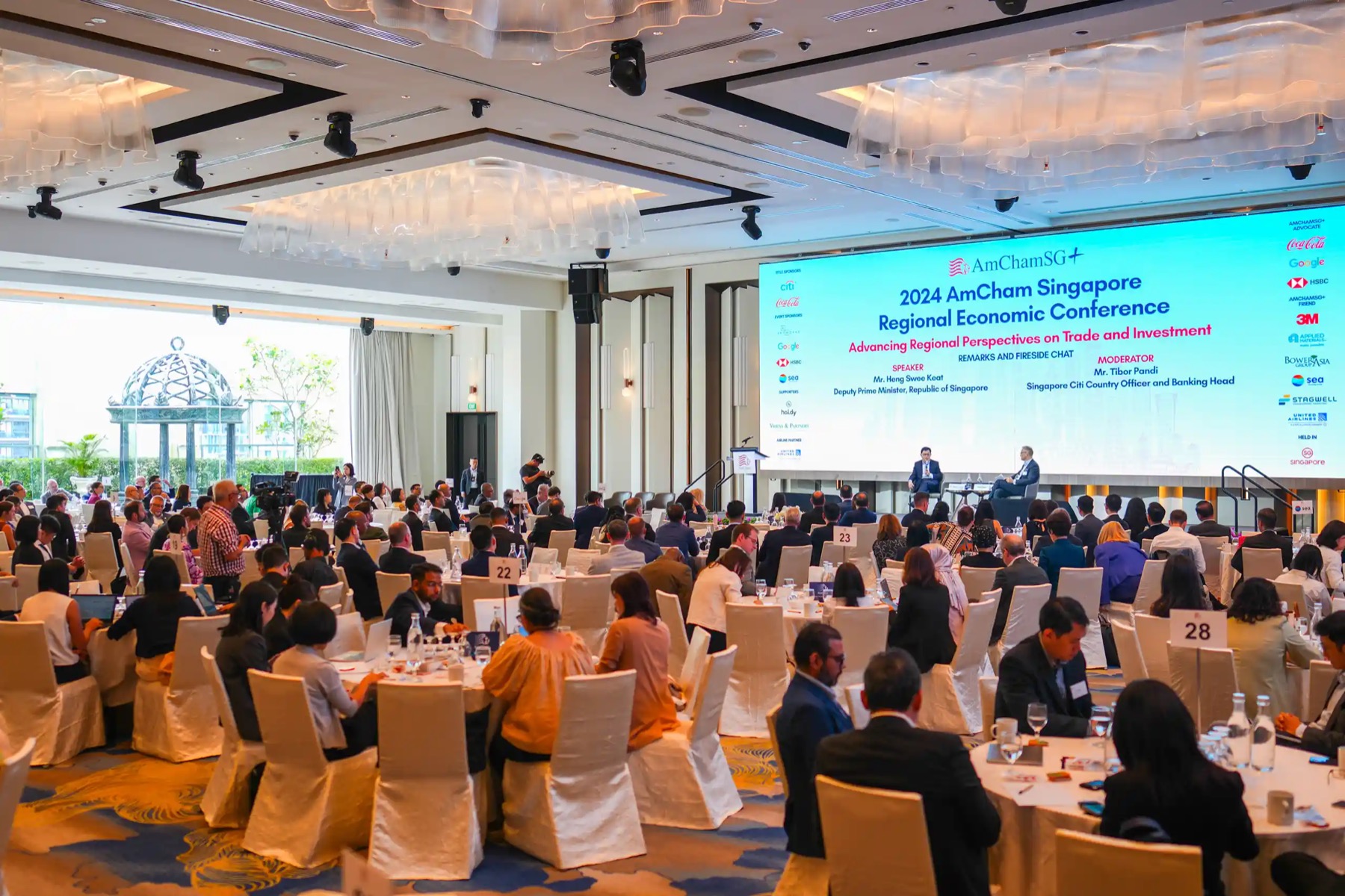 A seated conference audience facing a fireside chat at the 2024 AmCham Singapore Regional Economic Conference